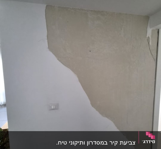 קיר עם טיח חלקי בתהליך צביעה